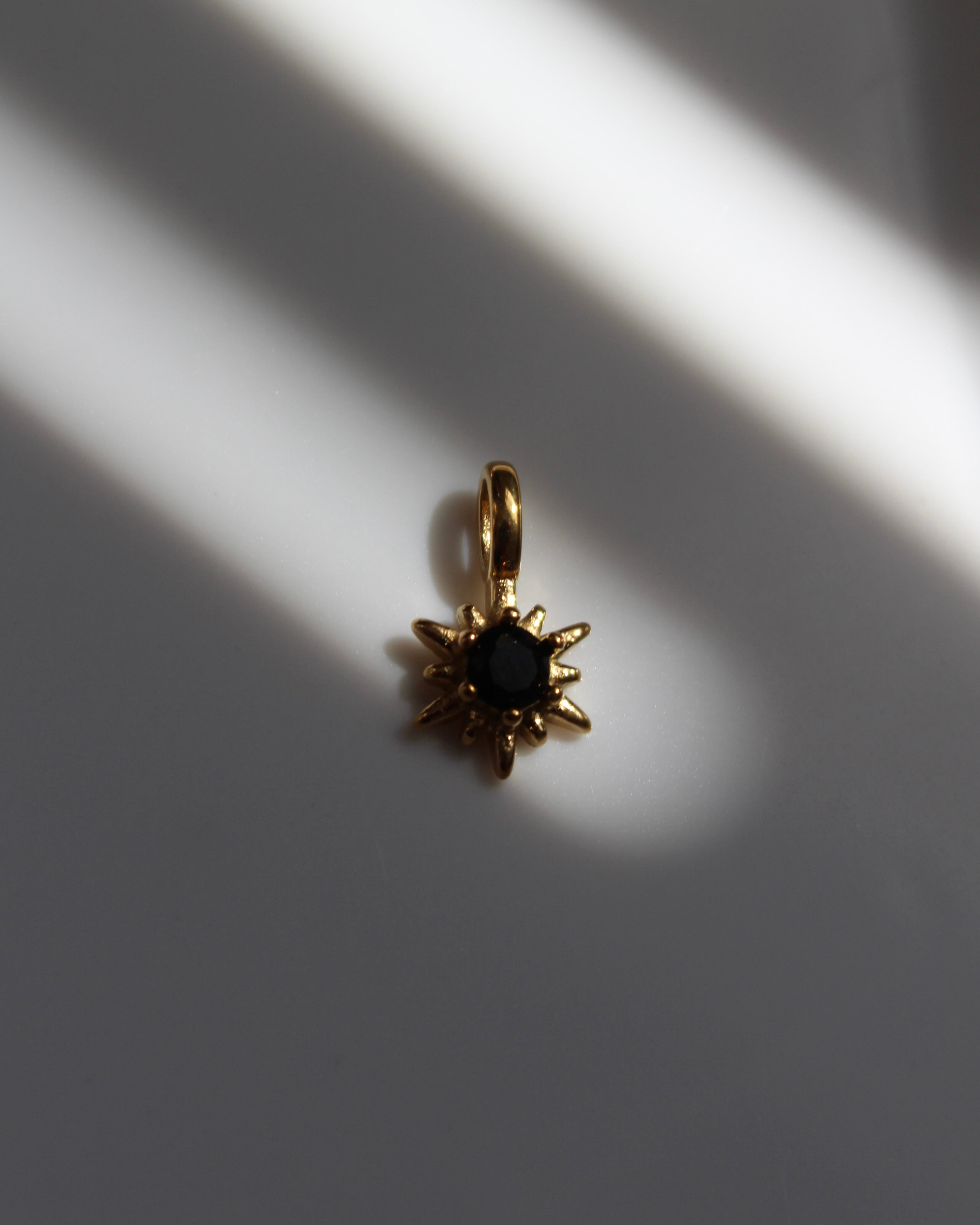 Gold Star Charm with Black Stone.
