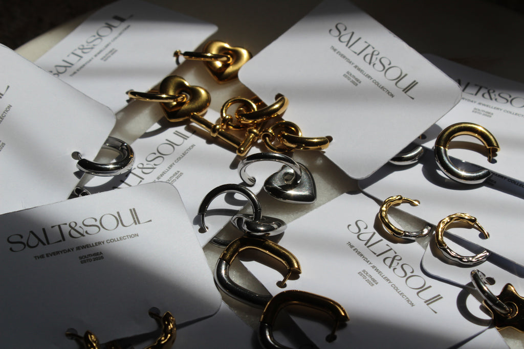 Gold and silver C-shaped hoop earrings displayed on white cards printed with the brand name 'SALT&SOUL'.